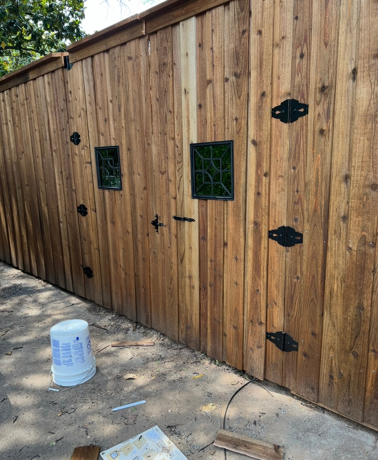 Custom wood gate with decorative iron windows in Sanger TX by Landeros Fence